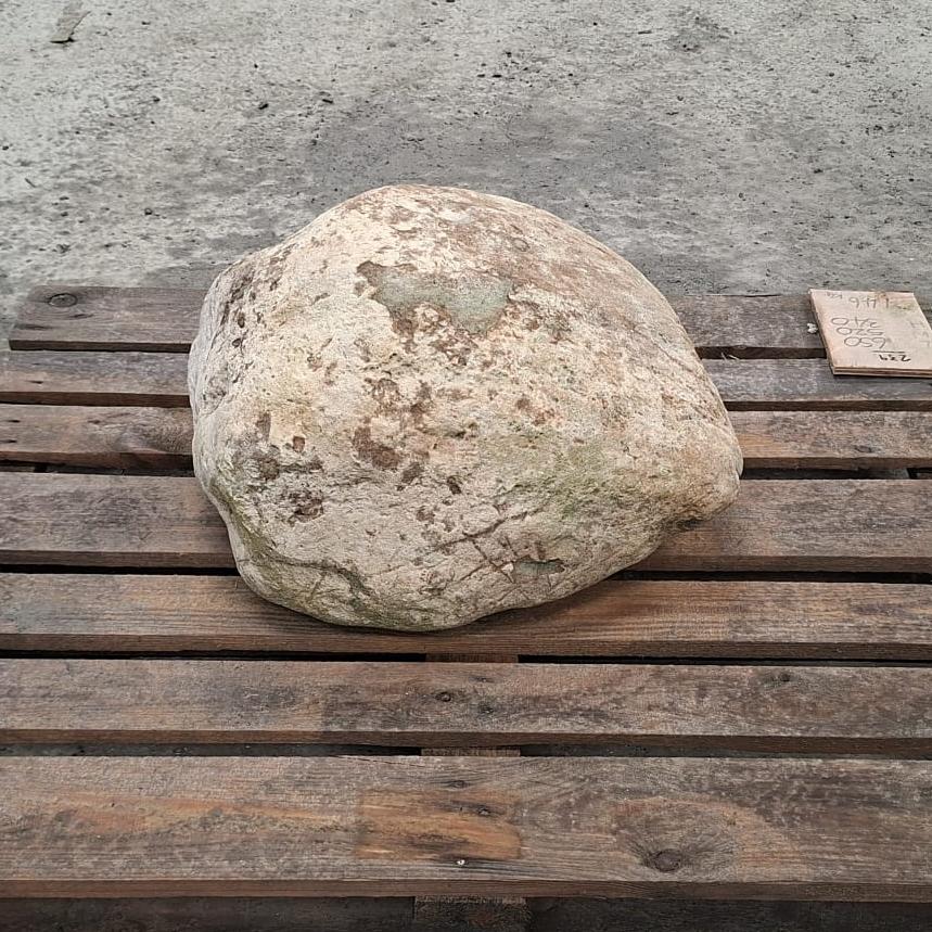 A glacial stone boulder displayed on a pallet. This boulder has a relatively smooth natural surface and light colour tones.