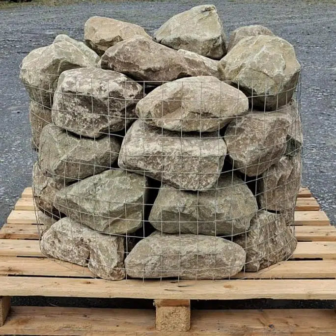 Glacial rockery stones stacked in a wire cage on a wooden pallet