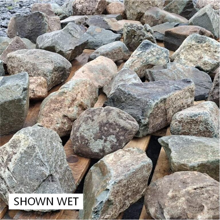 Wet mixed glacial stones with pink, grey and greenish surfaces