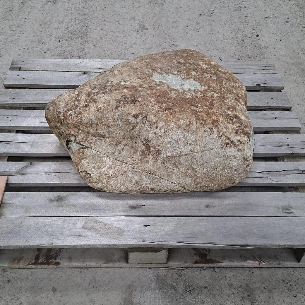 A glacial stone boulder displayed on a pallet. This boulder has a unique shape and varying natural colour tones.