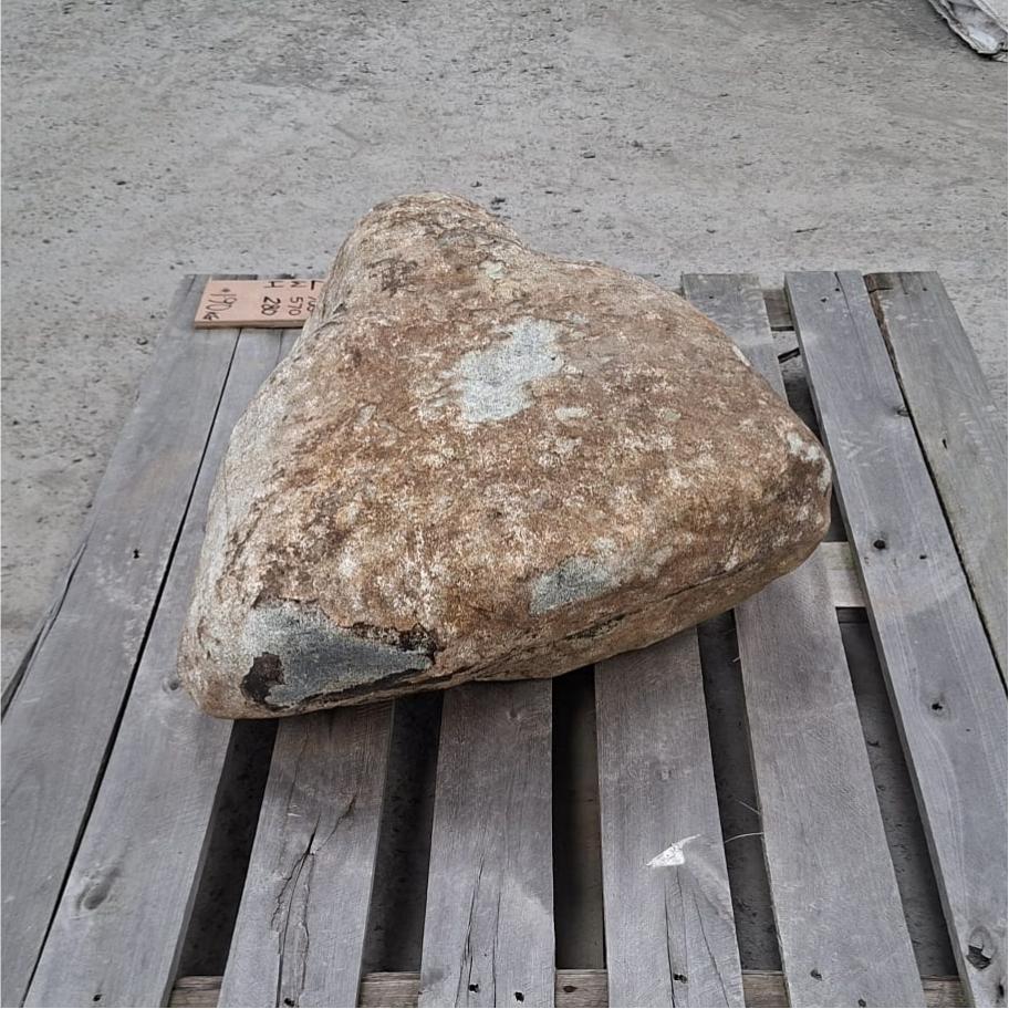 A glacial garden boulder with unique shape displayed on a pallet, showing the textured surface and different colour tones.