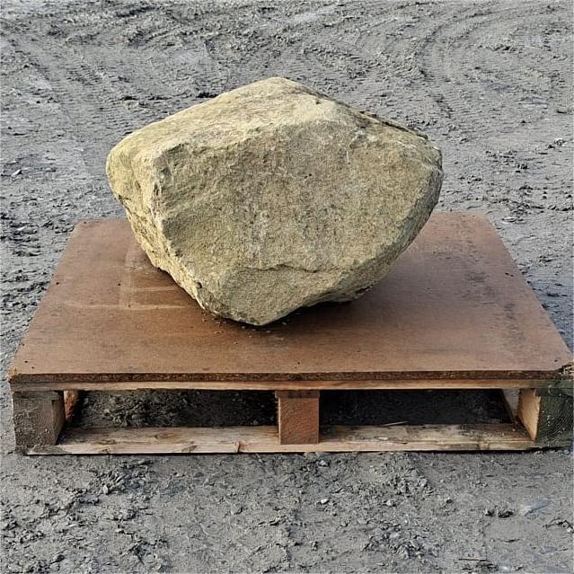 Angular glacial boulder with a broad olive grey face on a pallet
