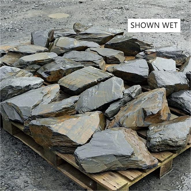Large wet slate pieces spread across pallets, showing varied shapes