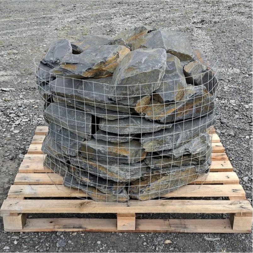 Welsh slate rockery stones stacked in a wire cage on a pallet