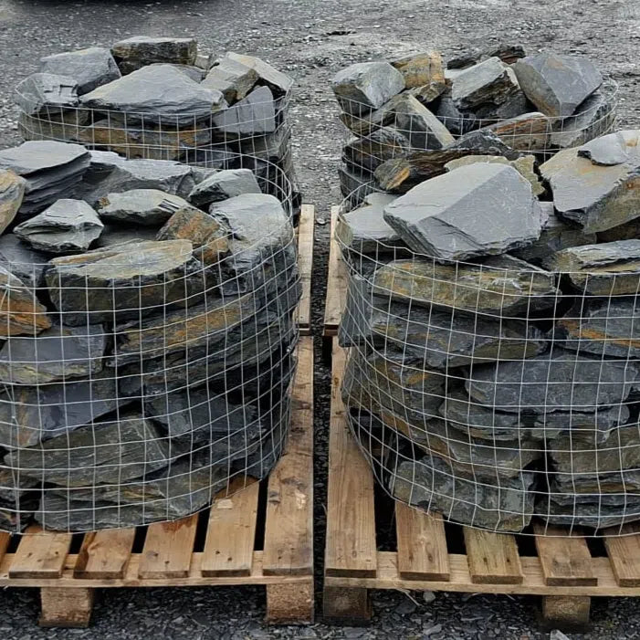Four pallets of caged slate rockery stones with broad grey faces