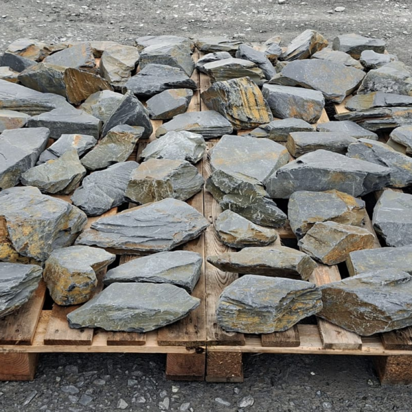 Dry slate stones laid out with broad grey faces and ochre edges