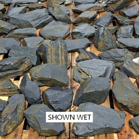 Wet slate pieces laid out to show striped textures and angular shapes