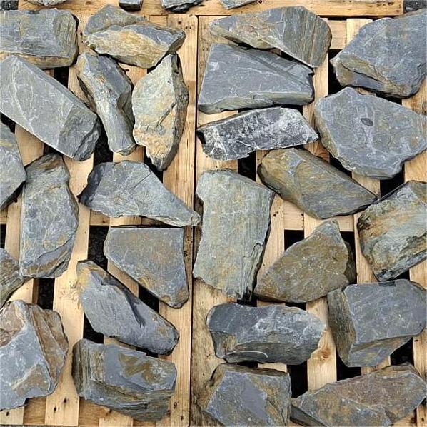 Dry slate rockery stones arranged individually across wooden pallets