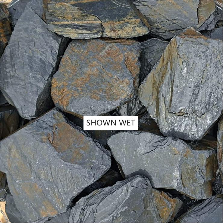 Close-up of wet slate showing layered grey surfaces and rusty markings