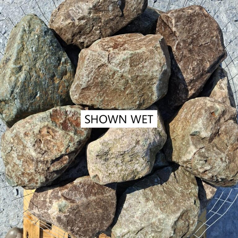 Close-up of wet glacial stones with rusty markings and greenish grey surfaces