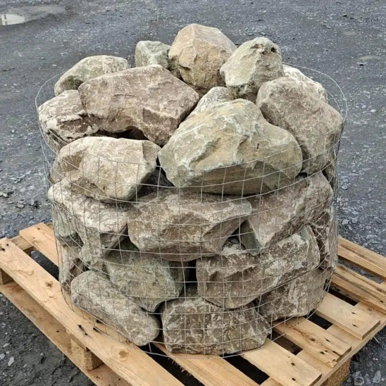 Caged glacial rockery stones with pale mottled faces on a wooden pallet