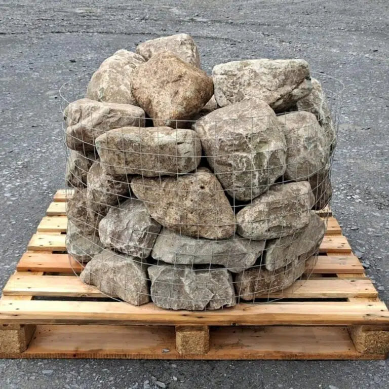 Glacial rockery stones stacked behind wire mesh on a square pallet
