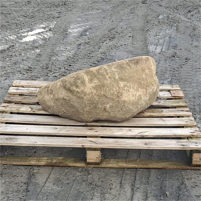 Wedge-shaped glacial boulder with a sloping top and tan mottled surface