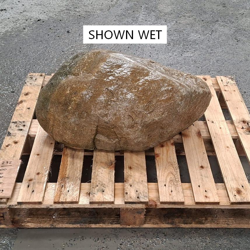 A wet glacial stone boulder on a pallet.