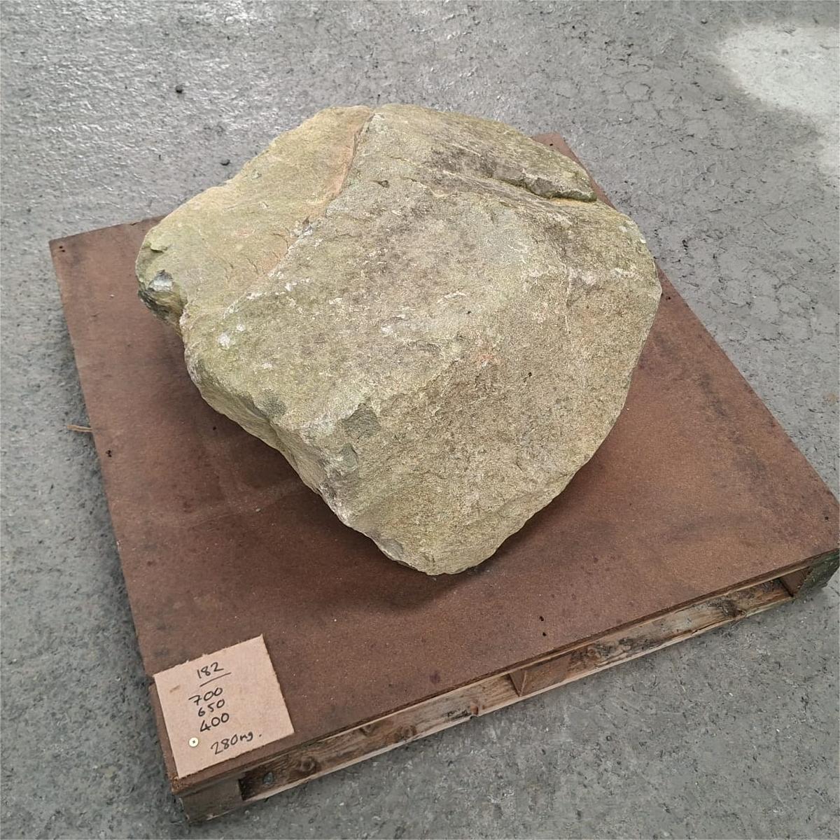 Glacial boulder seen from above, showing a broad flat face and fine cracks