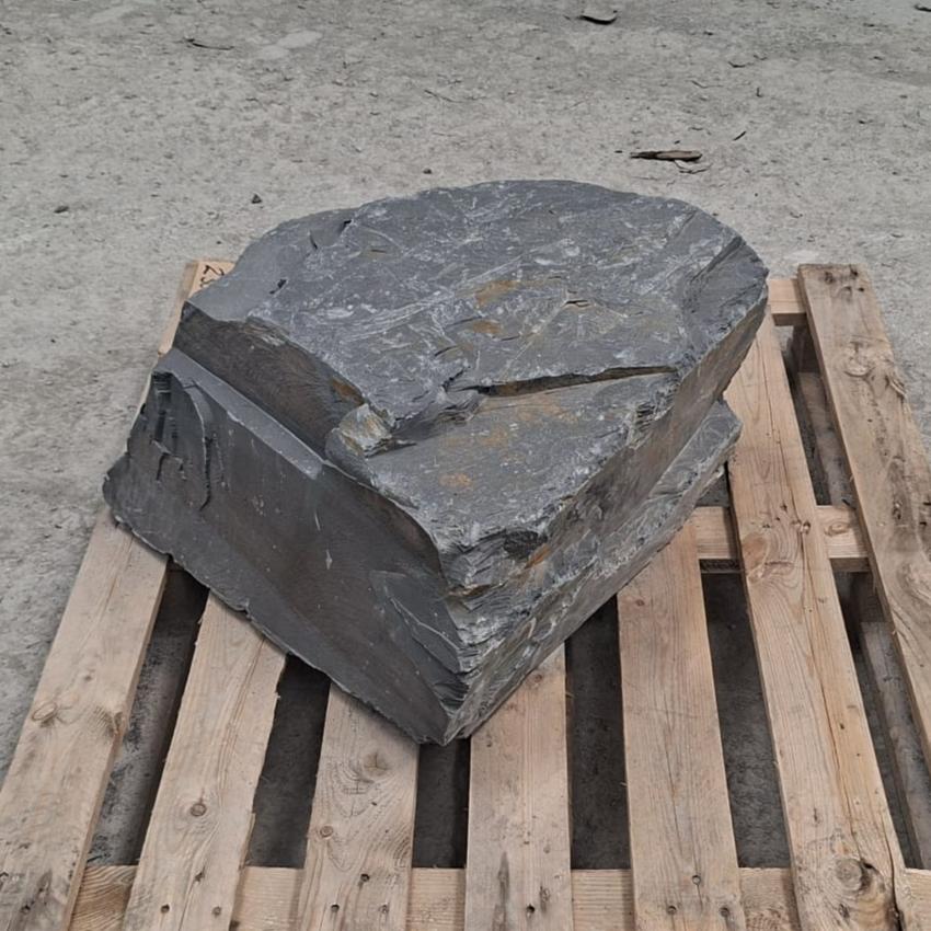 Welsh slate boulder showing a broad flat top and sharply layered corner