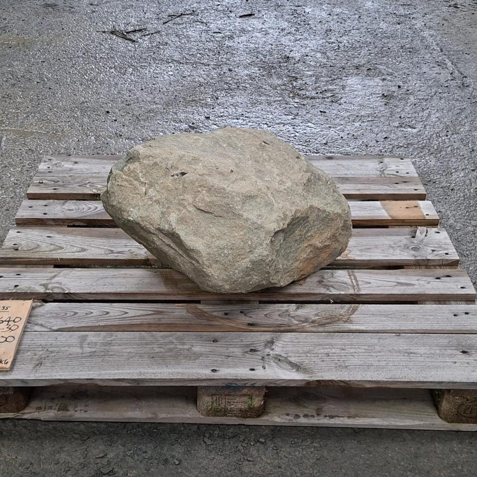 A garden boulder resting on a wooden pallet.