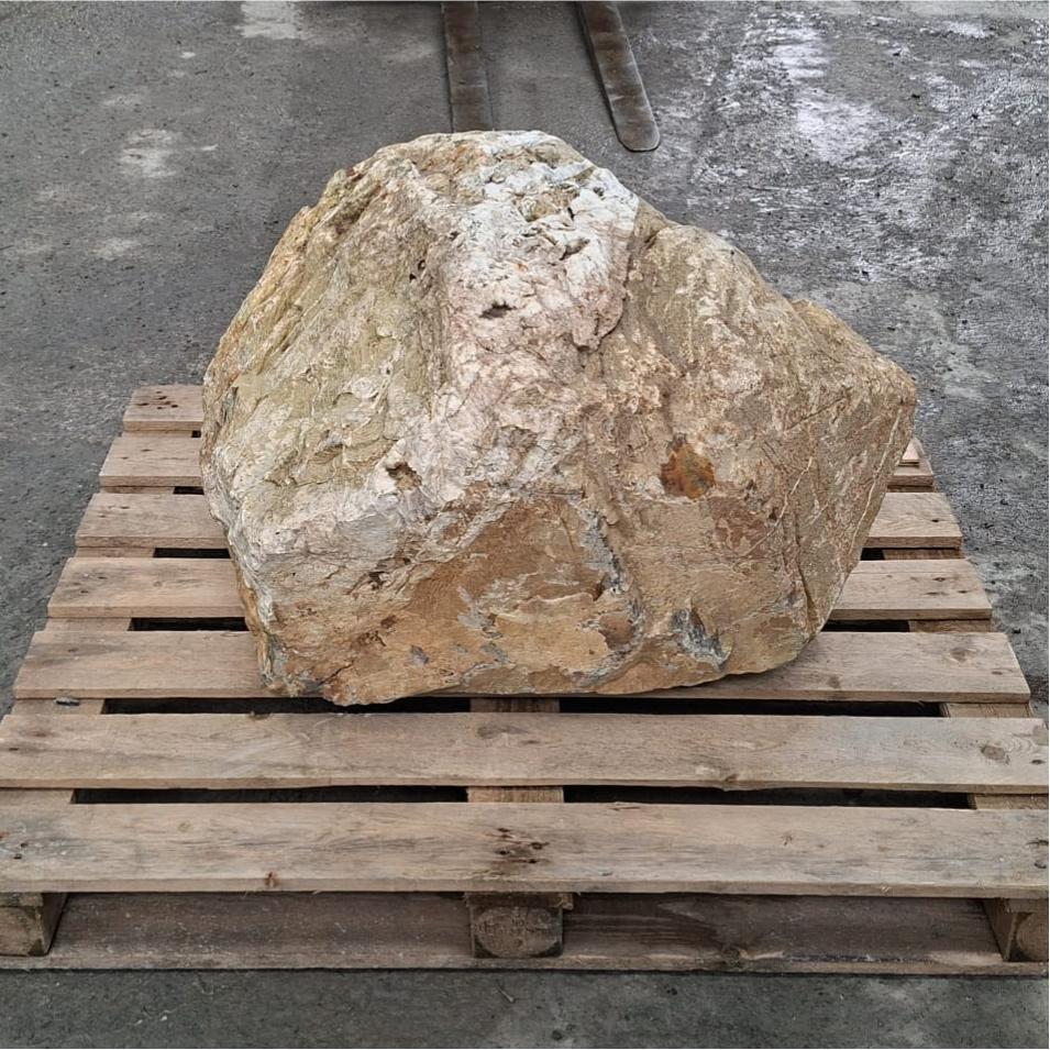 A large rough natural stone boulder with natural colours and textures.
