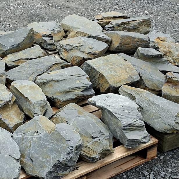 Large dry slate stones with angular grey faces and golden brown edges