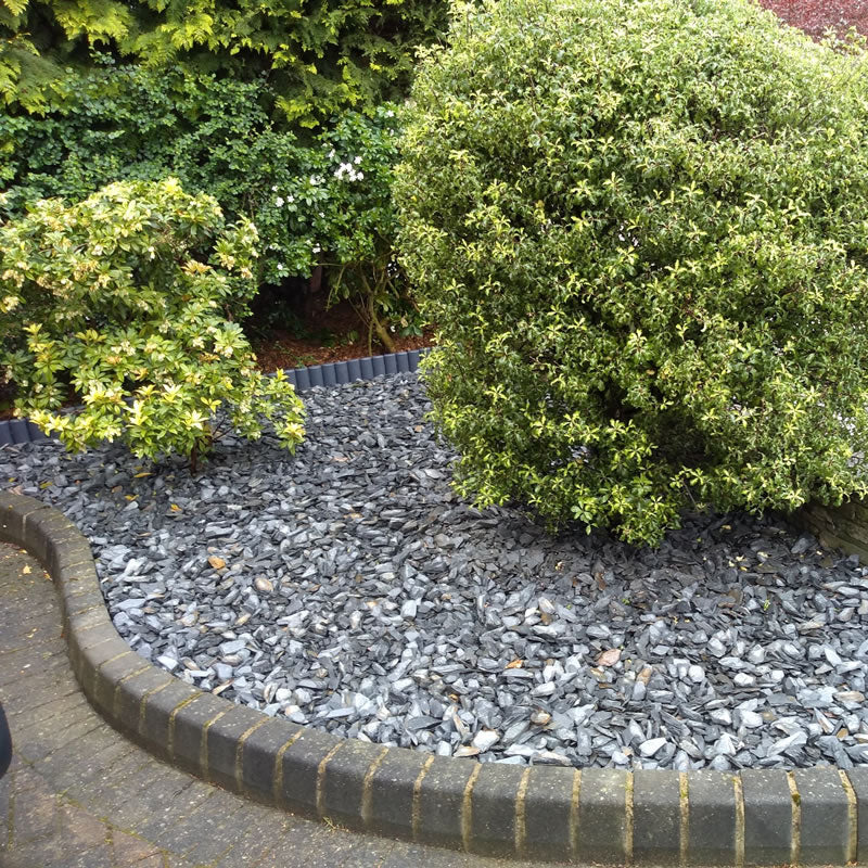 Welsh slate chippings covering a curved garden bed beneath shrubs