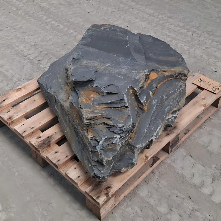 Angular Welsh slate boulder showing a pointed corner and orange brown seams