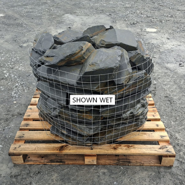 Wet Welsh slate rockery stones stacked in a pallet cage