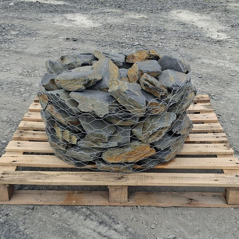 Mini Welsh slate rockery stones in a wire cage on a wooden pallet