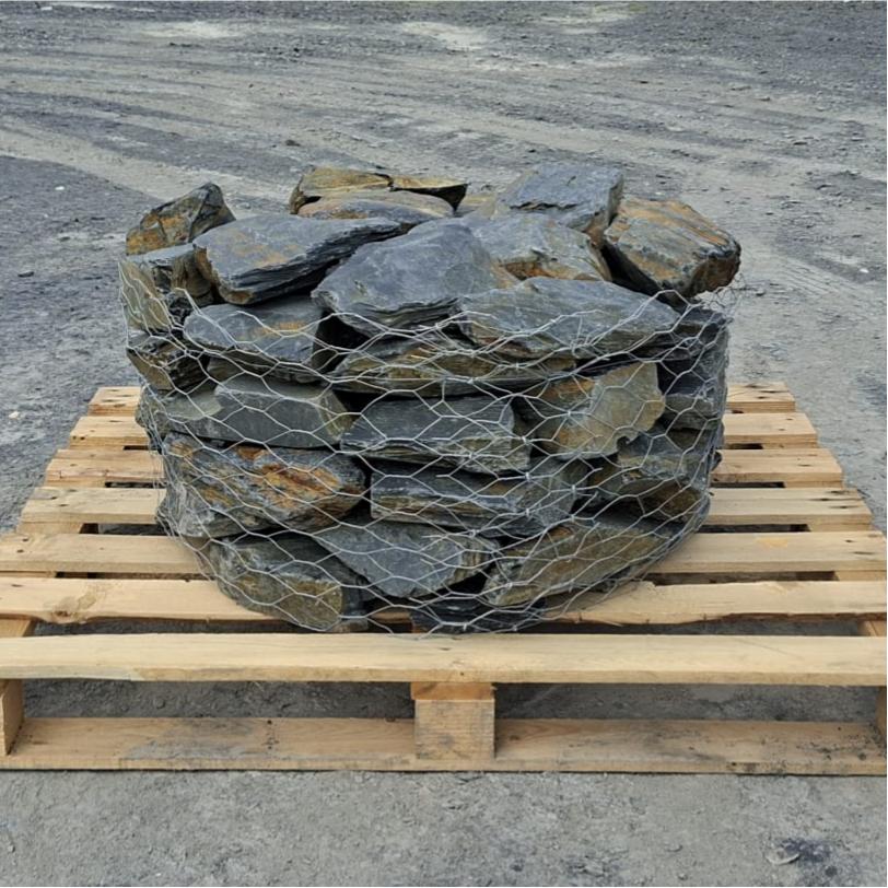 Welsh slate rockery stones in a wire cage on a wooden pallet