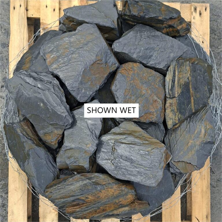 Wet slate stones packed together on a pallet, photographed from above