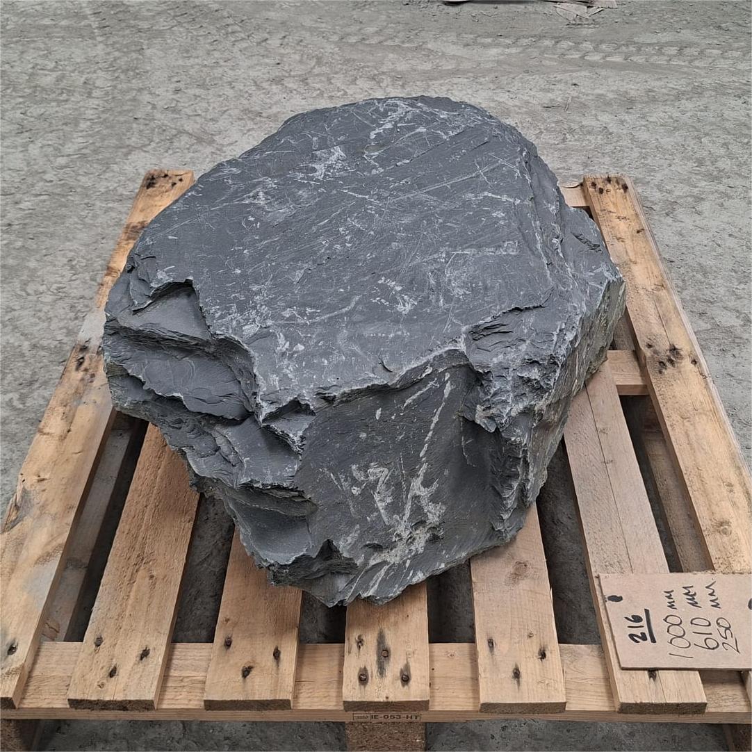 Slate boulder with flat top and pointed edge.